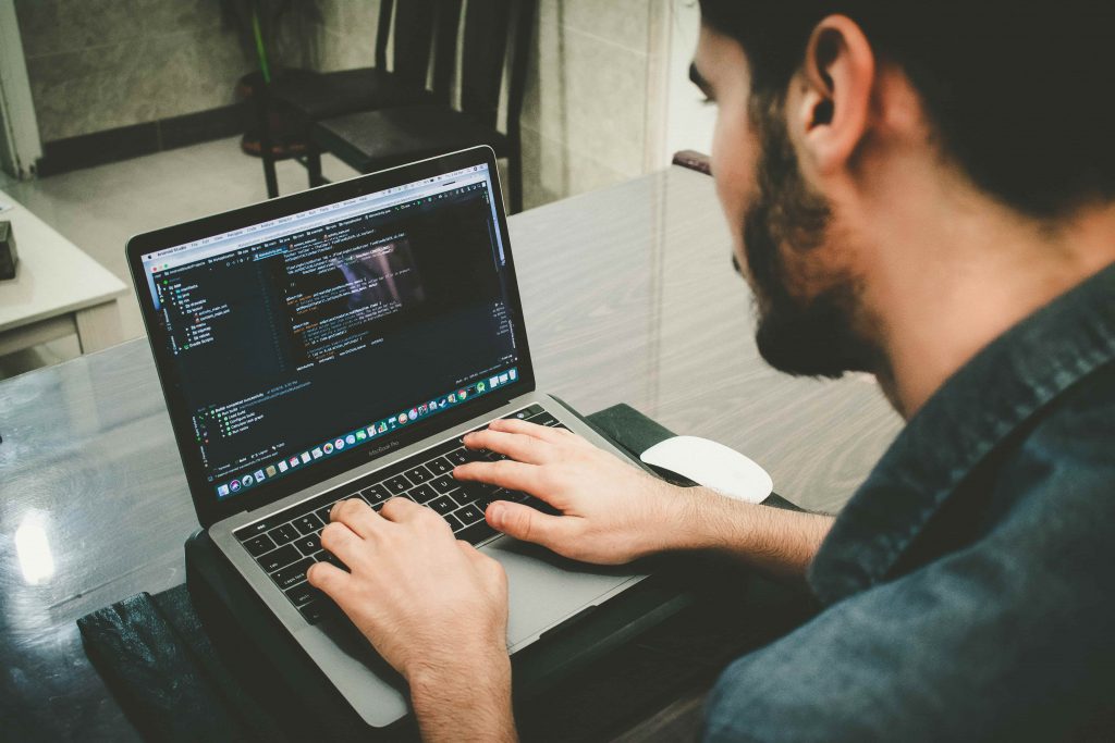 homem escrevendo códigos no computador