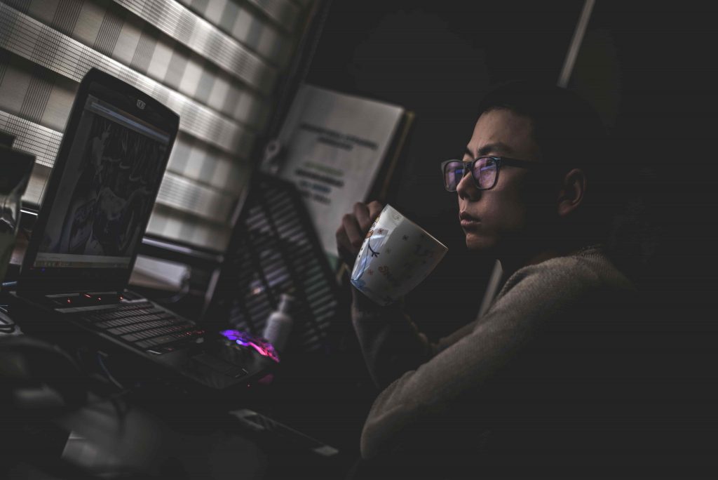 homem oriental olhando para o computador