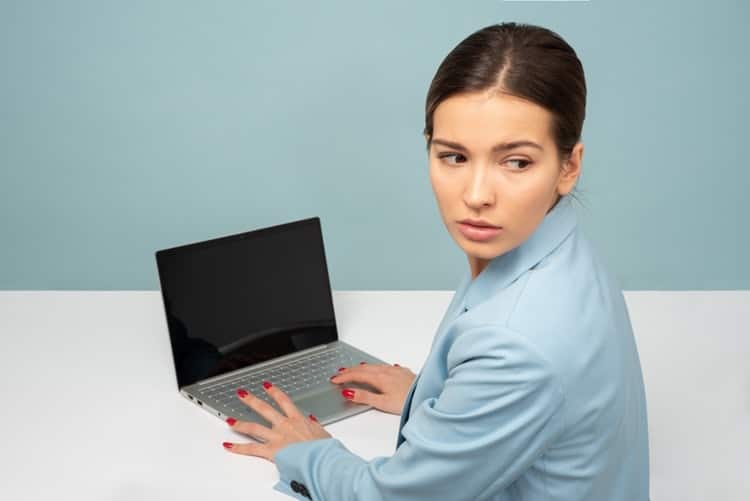 mulher usando o computador com cara de desconfiada